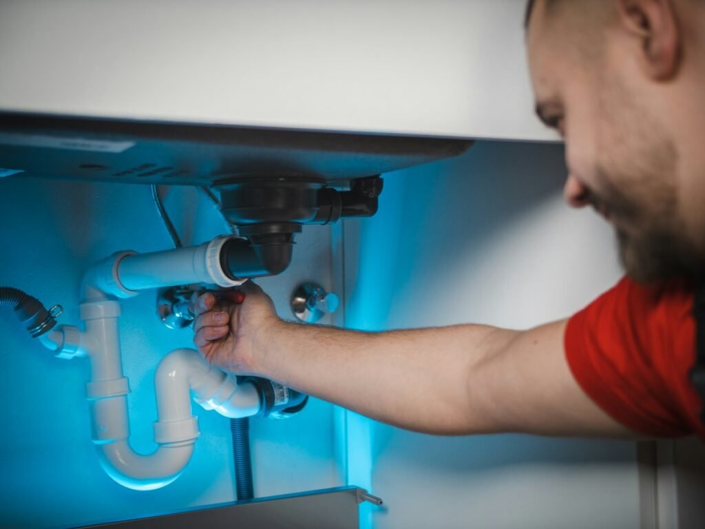 Plumber working on pipes