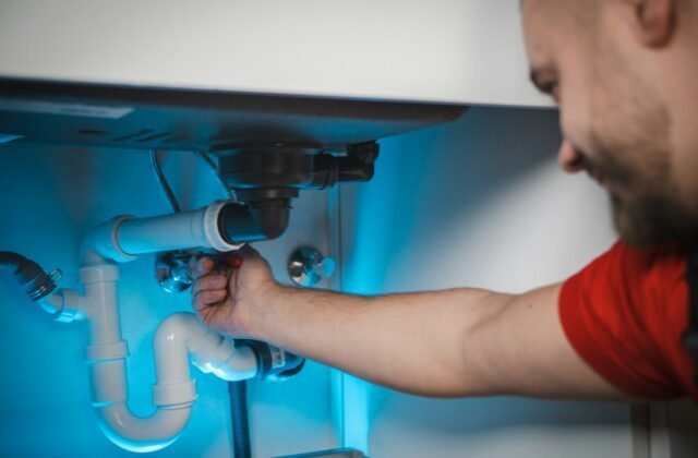 Plumber working on pipes